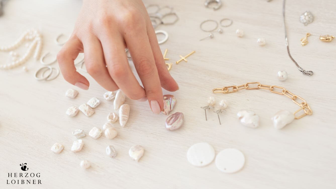 Hand greift nach Schmuck um Schmuck selbst zu gestalten